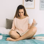 woman-with-mug-reading-book-bed_23-2147896575
